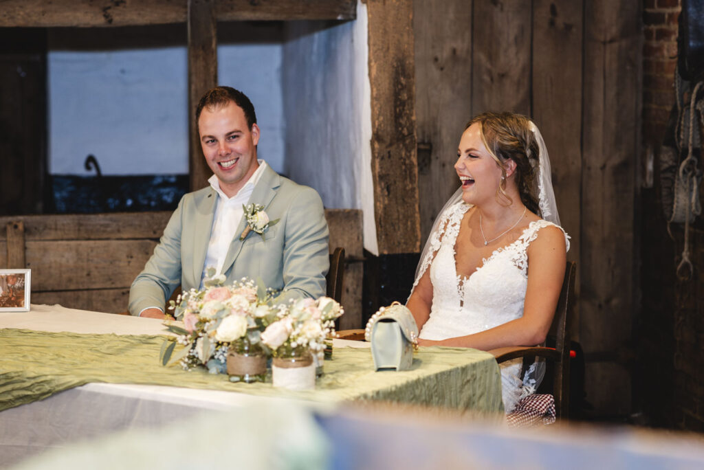 Bruidspaar lachend tijdens ceremonie